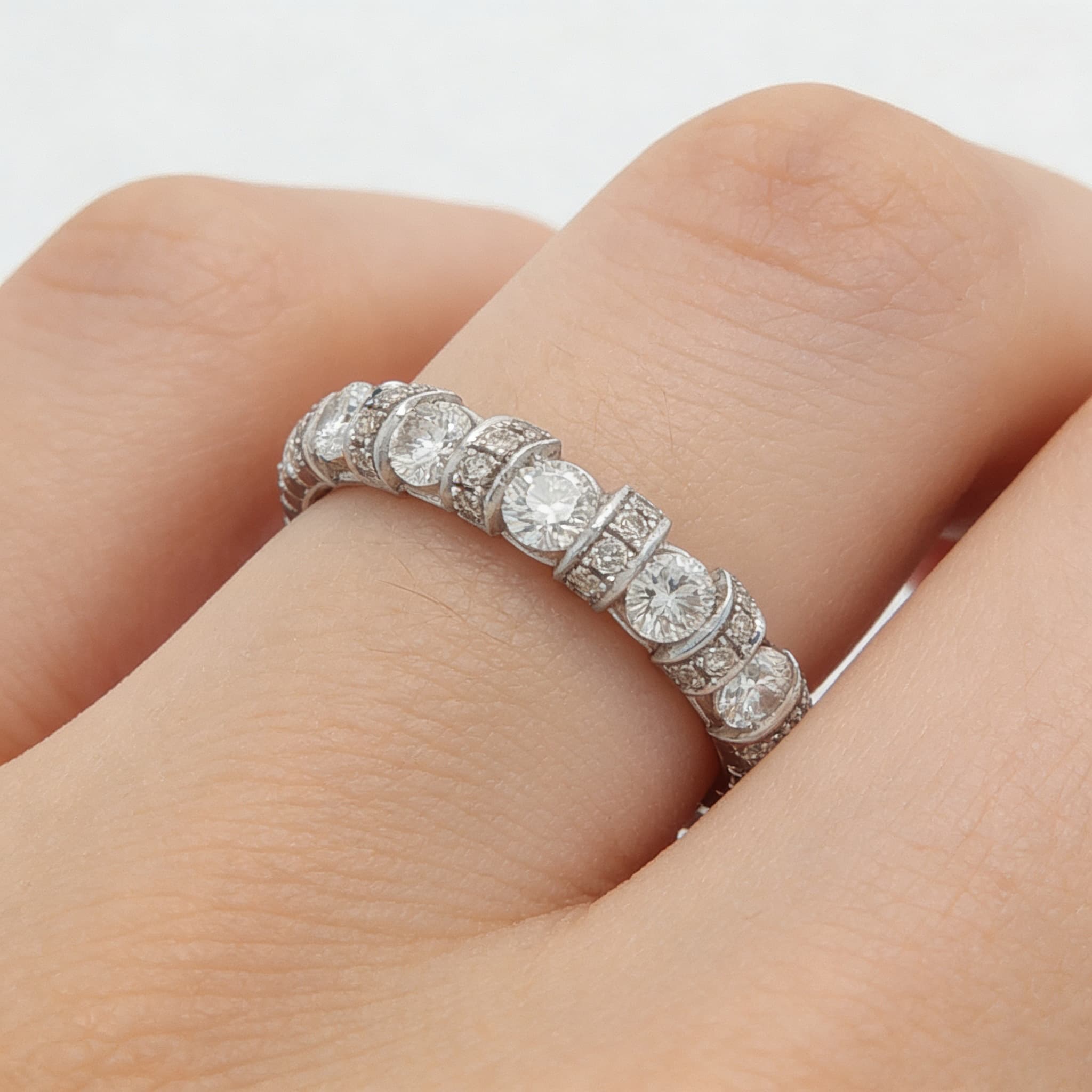 The Eternità Four-Prong Round Diamond Eternity Ring with Pavé Spacers